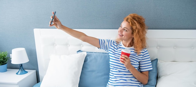 Woman blogger smile with coffee making selfie on phone selfie time woman has video phone call