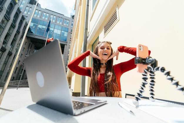 Woman blogger in a summer cafe streaming on the street