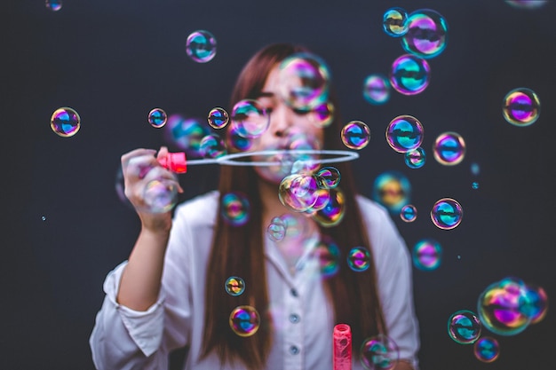 Photo woman blowing bubbles in city