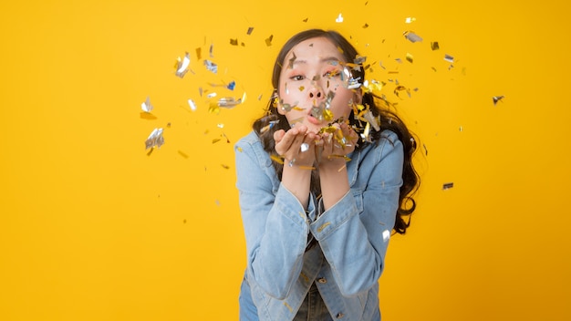 Photo woman blowing golden confetti paper