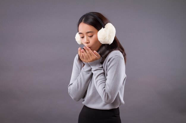 Woman blowing her hand to warm up from cold weather