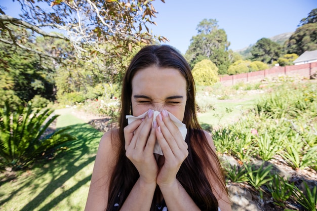 Photo woman blowing nose with tissue paper