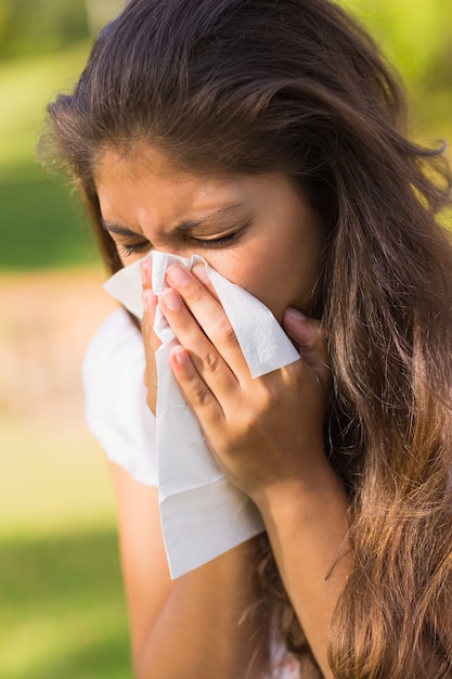 Woman blowing nose with tissue paper