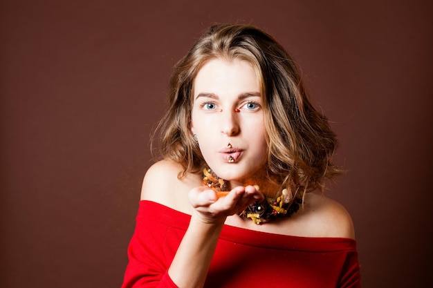 La donna soffia sulla spezia della paprica in polvere rossa. trucco creativo