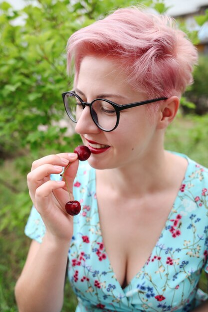 Woman in blue dress holding a handful of sweet cherries