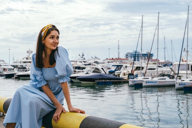 Photo a woman in a blue dress is sitting on a yellow boat