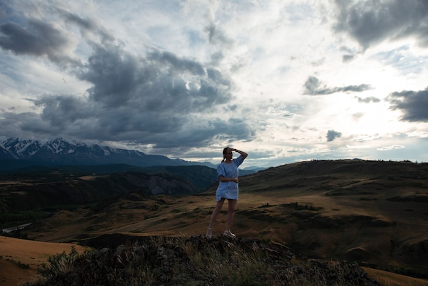 Woman in blue dress in summer altai mountains in kurai steppe