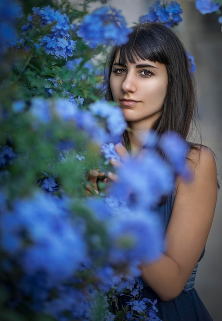 Foto una donna in un giardino fiorito blu