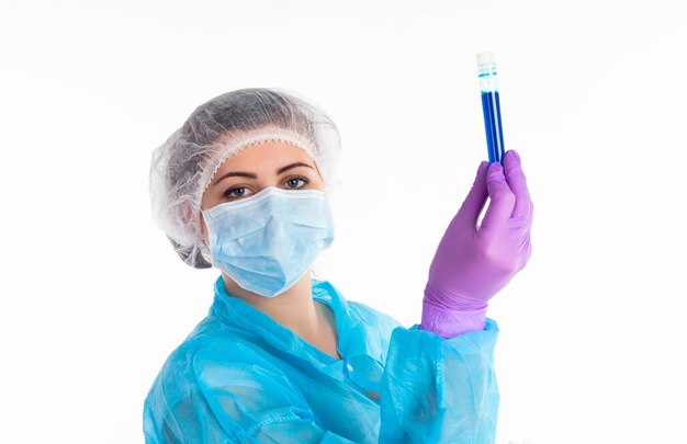 The woman in a blue protective coat and hat is showing a navy liquid on a white background.