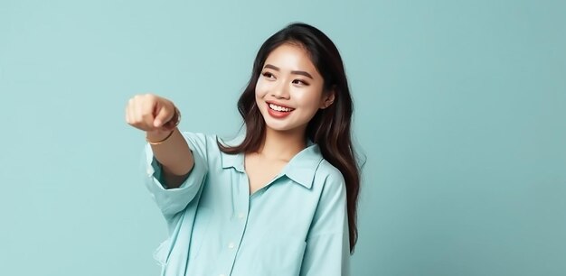 A woman in a blue shirt points to the camera.