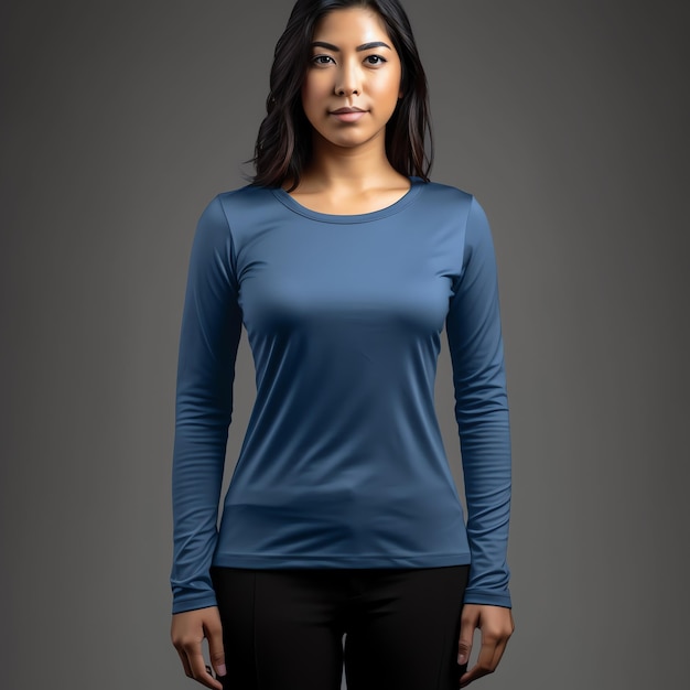 A woman in a blue shirt stands in front of a grey background