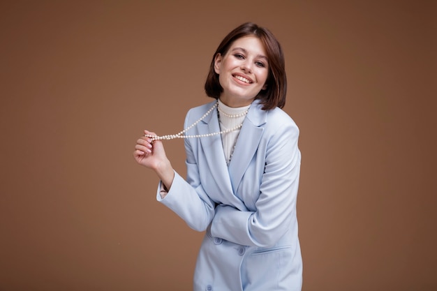 Woman in blue suit in the style of a flight attendant stewardess on brown background Bob haircut