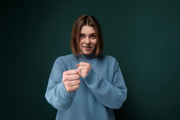 Woman in blue sweater making fist gesture