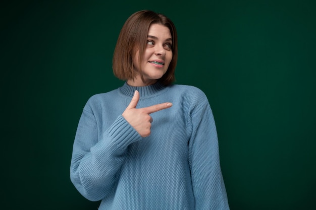 Woman in blue sweater points at something