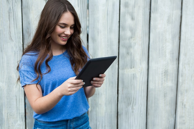 Woman in blue top using digital tablet