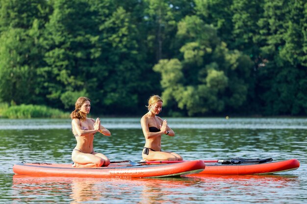 Photo woman in boat on lake against trees