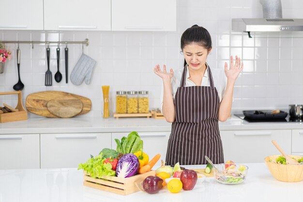 Donna annoiata a cucinare frustrata e assonnata.