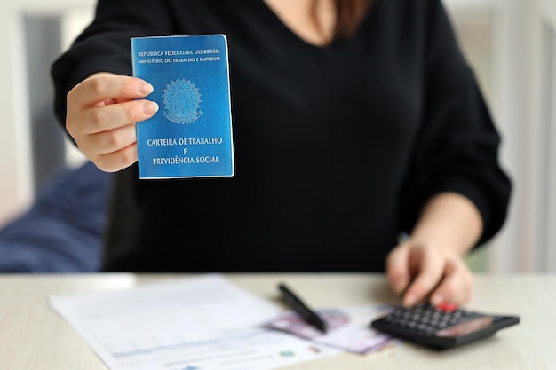 Photo woman boss gives a brazilian work card and social security blue book to us in employment office