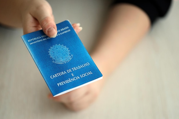 Foto il capo donna ci dà una carta di lavoro brasiliana e un libro blu della sicurezza sociale nell'ufficio del lavoro