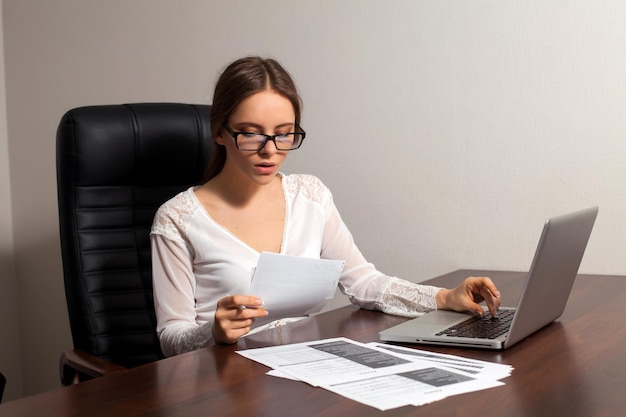 Woman boss is reading documents sitting in the office