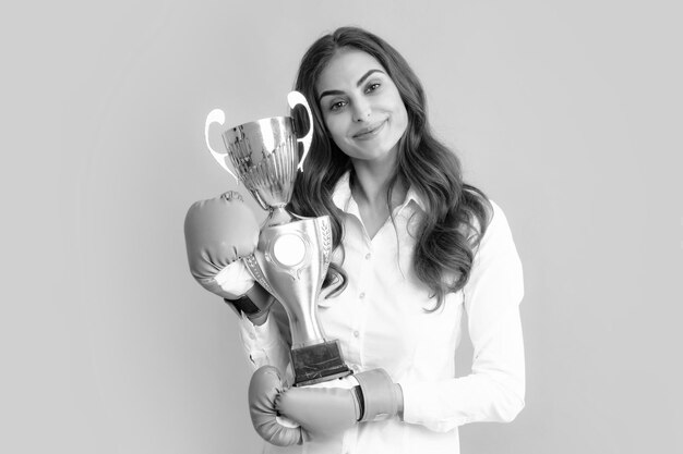 Woman in boxing gloves hold champion winner cup trophy Strong powerful girl competition concept