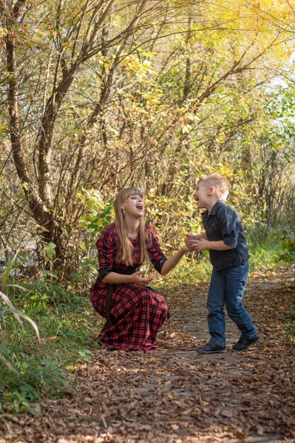 A woman and a boy are playing in the woods.