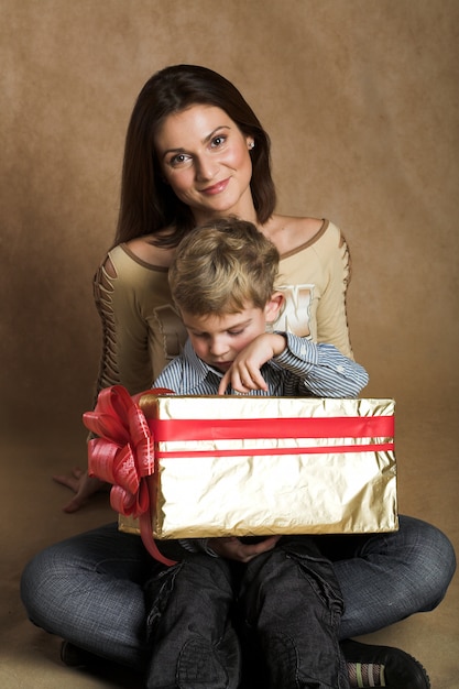 Женщина и мальчик проверяют Рождество или подарок на день рождения