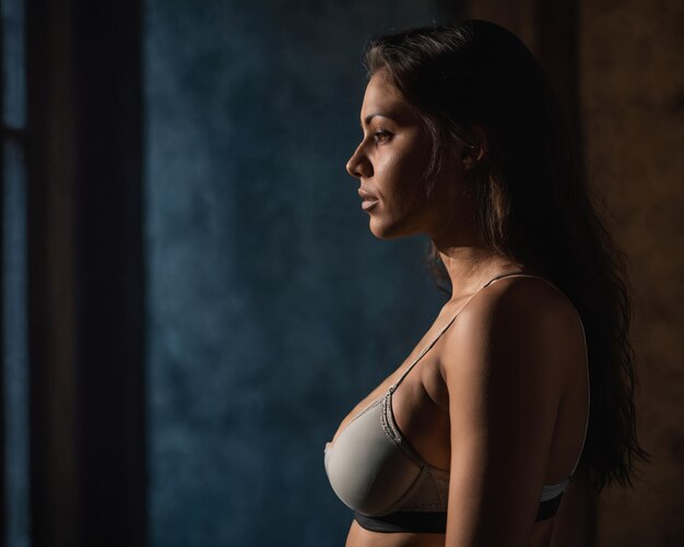 A woman in a bra top standing in front of a window