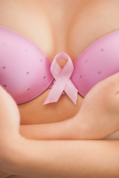 Woman in bra with breast cancer awareness ribbon