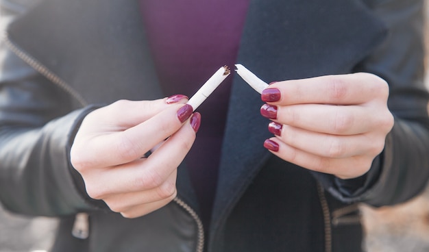 Woman breaking cigarette. Quit smoking