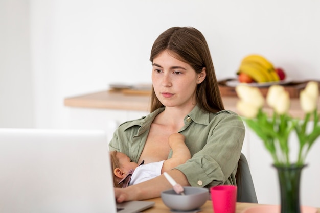 Foto donna che allatta durante il lavoro