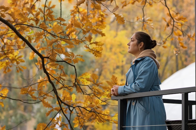 Woman breathes deeply and smiles enjoying autumn nature