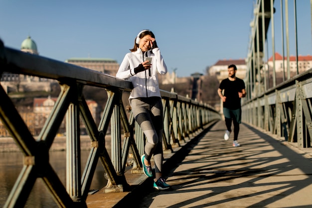 運動後に一時停止する橋の女性