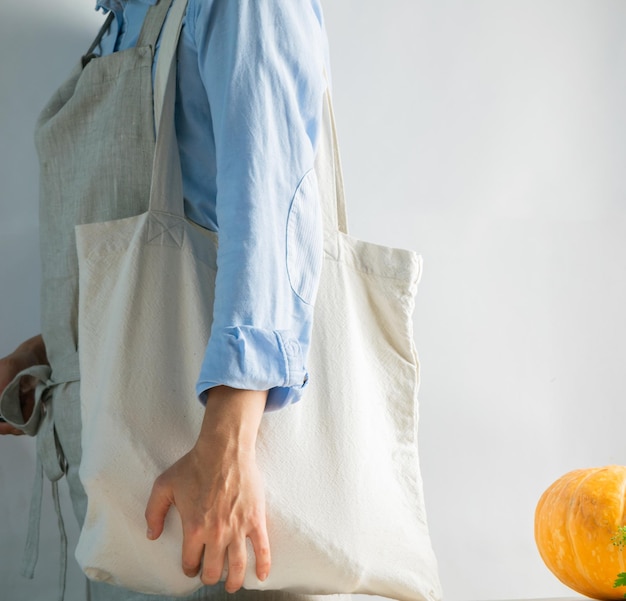 Photo a woman in bright clothes holds a cotton bag made of natural fabric rustic natural style kinfolk style copy space