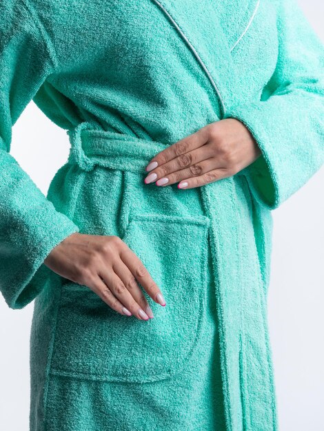 Woman in a bright dressing gown advertises clothing details on an isolated white background