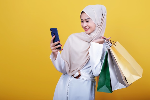 woman bring shopping bag and using mobile phone cheerful