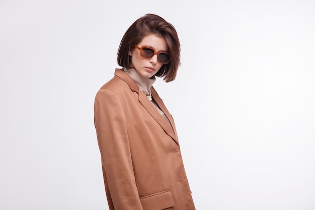 Woman in brown beige suit corset sunglasses jacket pants on white background Bob haircut