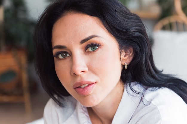 woman brunette sitting at home look at camera