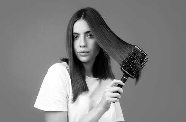 Woman brushing hair with comb Beautiful girl combing long hair with hairbrush