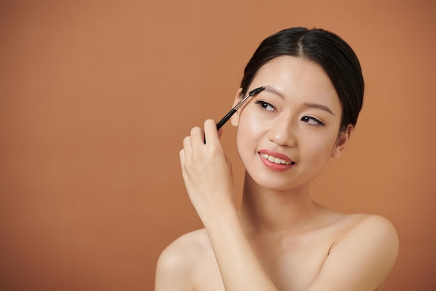 Woman Brushing up Eyebrows