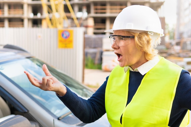 A woman builder at a construction site inspects a building