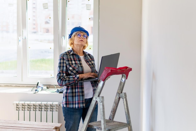 Woman Builder in the room of the house making repairs.