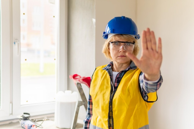 Photo woman builder in the room of the house making repairs