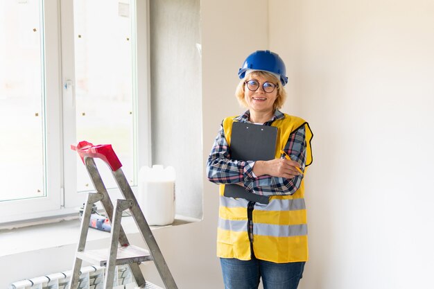 Woman Builder in the room of the house making repairs.