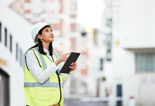 Woman building manager and construction on tablet doing inspection and working on site in the city female architect or builder contractor checking architecture at work on touchscreen technology