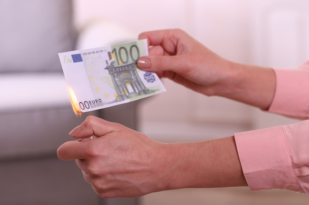 Woman burning Euros in the room