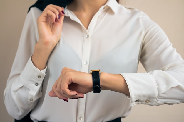Photo woman in business attire looking the time on hand watch closeup