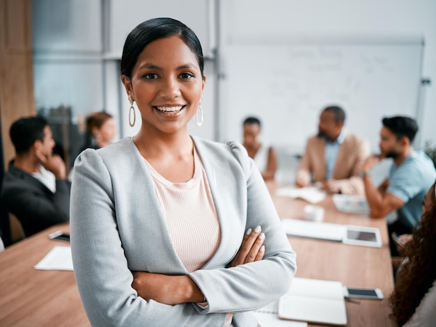 A confident woman standing at the head of a boardroom table
