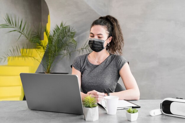 Woman in a business office wearing medical mask