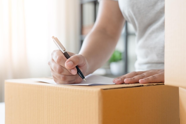 Woman business owner writing down customer address to deliver parcel